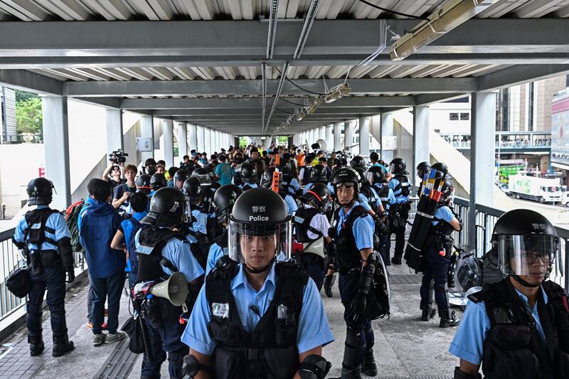 2019年6月13日,示威者在香港立法会外反《逃犯条例》,警察以暴力手段驱离示威民众后,警方在政府总部附近的天桥上守卫。(法新社)